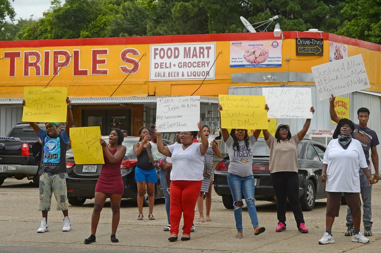 Family and friends of Alton Sterling protest Tuesday afternoon, after Sterling was fatally shot in an altercation with Baton Rouge Police just after midnight, in the parking lot of the Triple S Food Store, in Baton Rouge, La. (Travis Spradling/The Advocate via AP)