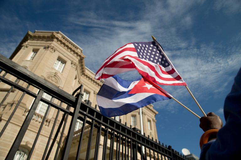 A Cuban-American holds an American flag and a Cuban flag as he celebrates outside the new Cuban embassy in Washington, Monday. (AP Photo/Andrew Harnik)