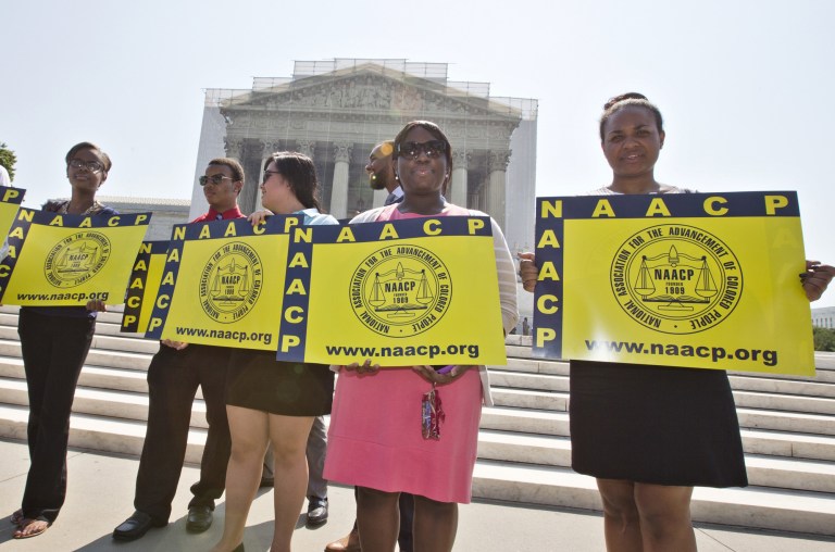 Representatives from the NAACP Legal Defense Fund stand outside the Supreme Court in Washington, Tuesday, June 25, awaiting a decision in Shelby County v. Holder, a voting rights case in Alabama. The Supreme Court says a key provision of the landmark Voting Rights Act cannot be enforced until Congress comes up with a new way of determining which states and localities require close federal monitoring of elections. (AP Photo/J. Scott Applewhite)