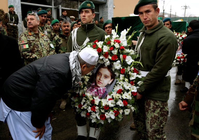 FILE - In this Sunday, March 23, 2014 file photo, Shah Mohammad, older brother of killed Afghan Agence France-Press journalist Sardar Ahmad attempts to give a kiss to his niece Nilofar's picture during a funeral ceremony in Kabul, Afghanistan. Sardar, his wife and two of his young children were killed when four gunmen attacked the Serena hotel in Kabul during New Year's celebrations on March 20, 2014. The number of Afghan civilians, including children, killed in violence rose by nearly 17 percent in the first half of this year, compared with the same period in 2013 as the fight is increasingly taking place closer to homes in populated areas, the U.N. said Wednesday, July 9, 2014.(AP Photo/Rahmat Gul, File)