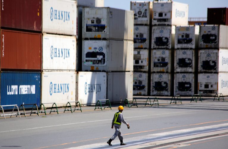 FILE - In this Aug. 20, 2014 file photo, a port worker walks past a piles of cargo at a container terminal in Tokyo. Japan has logged a 948.5 billion yen ($8.8 million) trade deficit in August, the 26th straight month of red ink, as weak demand at home hit imports while exports also fell. The Finance Ministry reported Thursday, Sept. 18, 2014 that exports fell 1.3 percent from a year earlier to 5.71 trillion yen ($53.3 billion) while imports dropped 1.5 percent to 6.65 trillion yen ($62.1 billion). (AP Photo/Eugene Hoshiko, File)