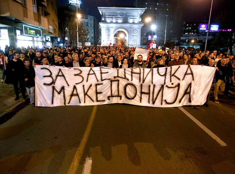 Thousands of people march through a street in Skopje, Macedonia, carrying a banner that reads "For Common Macedonia." (AP Photo/Boris Grdanoski)