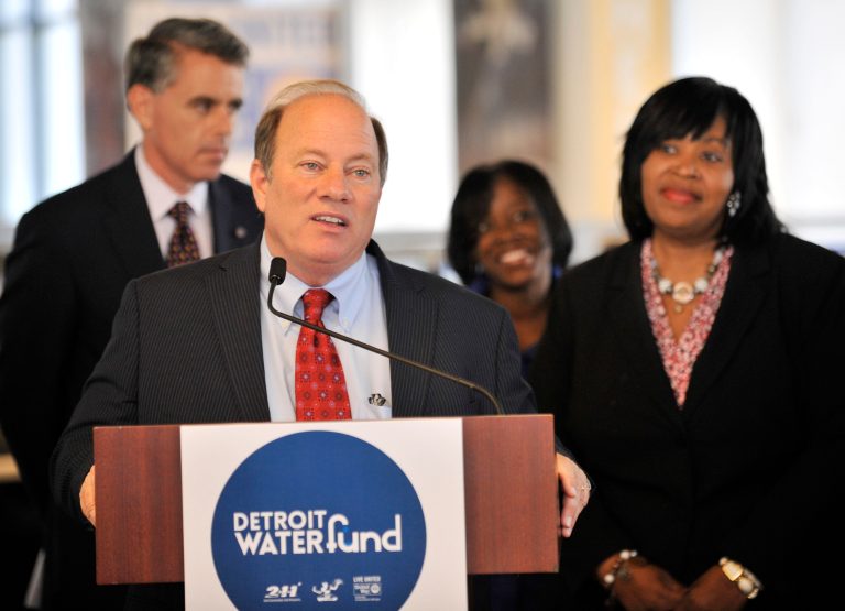Detroit mayor Mike Duggan speaks at a press conference Thursday, Aug. 18, 2014, in Detroit, as city council president Brenda Jones, right, looks on.  The mayor announced that $200,000 has been donated to the Detroit Water Fund by United Way, Ford Motor Company and General Motors. (AP Photo/The Detroit News,Robin Buckson)