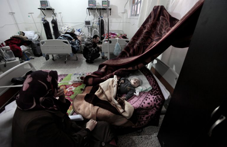   In this Tuesday, Dec. 18, 2012 photo, Mariam Darwish sits next to the bed of her four-month-old son, Fahed Darwish, who suffers a brain damage from a Syrian government airstrike, at an intensive care unit of a hospital in the village of Atmeh, Syria. Four-month-old Fahed Darwish is one of Syria's tens of thousands of war wounded: a missile slammed into his family home and shrapnel pierced his little skull. (AP Photo/Muhammed Muheisen)  