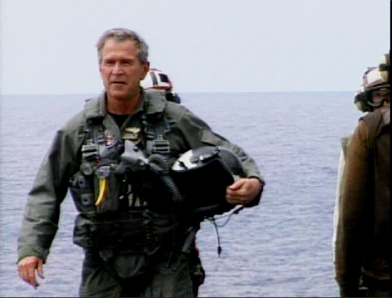 President George W. Bush walks on the deck after landing in a U.S. Navy S-3B Viking aboard the USS Abraham Lincoln, May 2003, in the Pacific Ocean off the coast of California. (AP Photo via APTN)