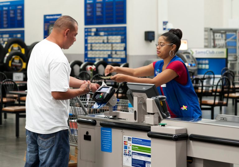 FILE - In this June 5, 2014 photo, Conquisia Tyler, right, gives change to a customer at Sam's Club in Bentonville, Ark. The Commerce Department releases retail sales data for July on Wednesday, Aug. 13, 2014. (AP Photo/Sarah Bentham, File)