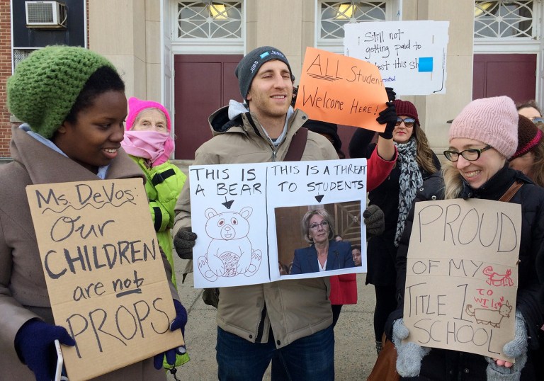 Protesters gather outside Jefferson Middle School in Washington where Education Secretary Betsy DeVos paid her first visit as education secretary in a bid to mend fences with educators after a bruising confirmation battle. (AP Photo/Maria Danilova)