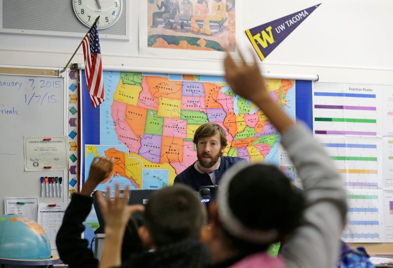 Bryan Johnson, a fifth grade teacher at Lister Elementary in Tacoma, Wash., calls on students raising their hands to answer questions, Wednesday, Jan. 7, 2015. (AP Photo/Ted S. Warren)
