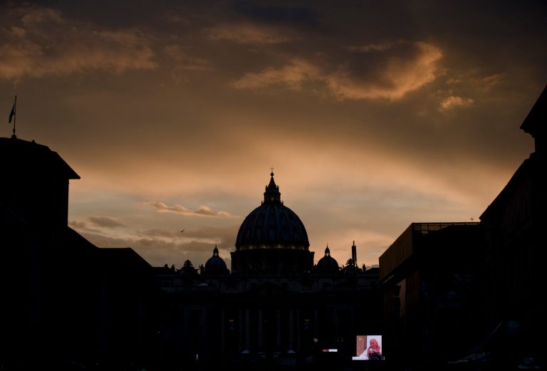 A large screen for public display shows Pope John Paul II after sunset outside St. Peter's Square at the Vatican, Saturday, April 26, 2014. Pilgrims and tourists streamed into Rome on Saturday to participate in the ceremony in St. Peter's Square that will see two popes, John XXIII and John Paul II, be proclaimed saints. (AP Photo/Vadim Ghirda)