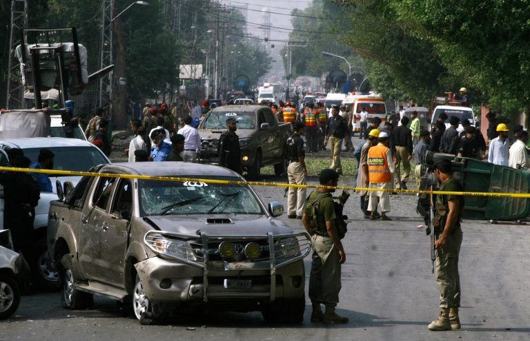 Pakistani security officials and rescue workers gather at the site of bomb blast in Peshawar, Pakistan, Tuesday, Sept. 23, 2014. A Pakistani police official says a roadside bomb has targeted a Pakistani army vehicle, killing several and wounded more than a dozen people in a northwestern city. (AP Photo/Muhammad Sajjad)