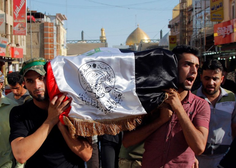Mourners carry the flag-draped coffin of Abdullah Swadi, a member of an Iraqi volunteer forces group who was killed during clashes with Islamic militants, his family said, during his funeral procession in the Shiite holy city of Najaf, 100 miles (160 kilometers) south of Baghdad, Iraq, Tuesday, July 8, 2014. (AP Photo/Jaber al-Helo)