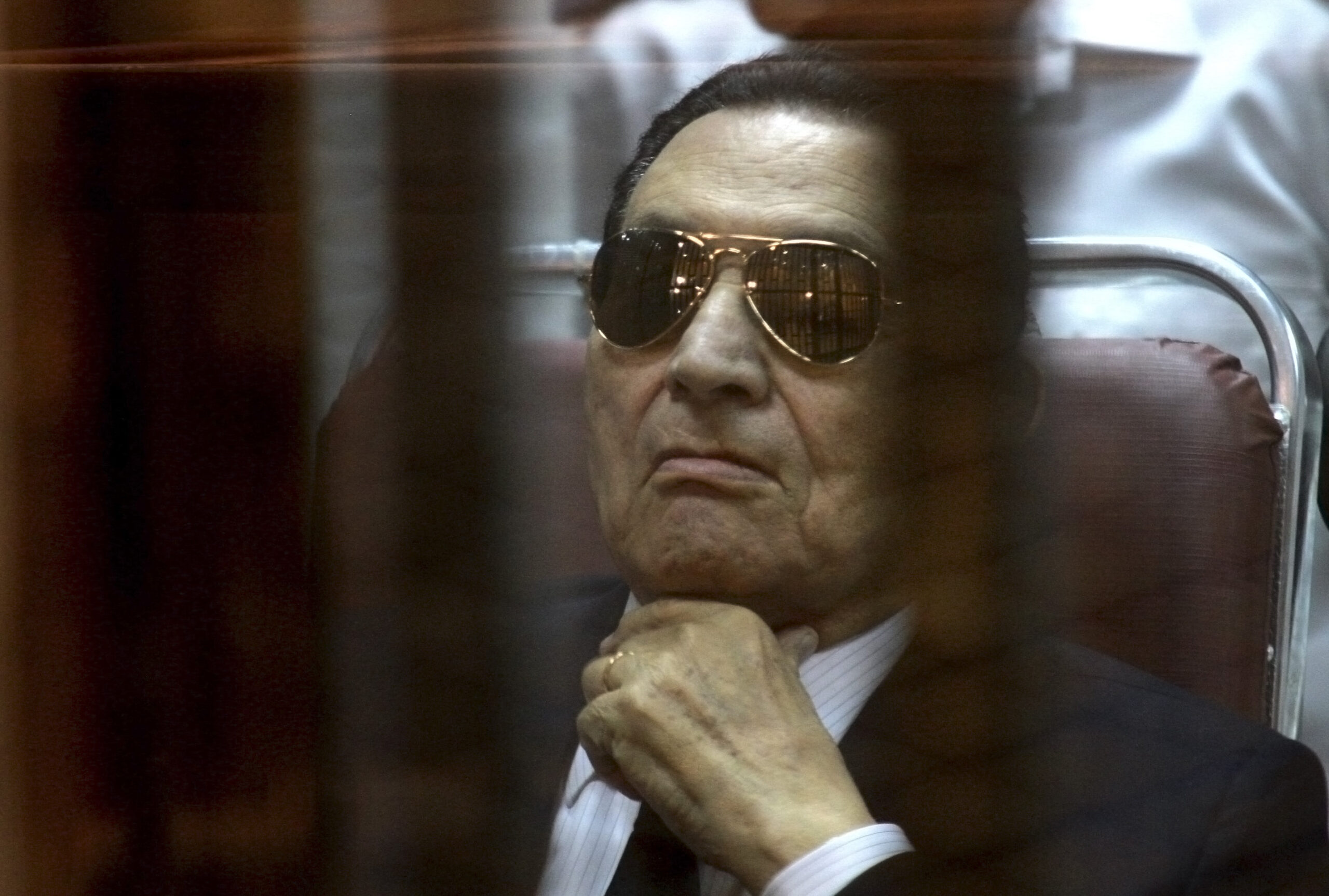 Egypt’s Mubarak defends his rule in courtroom cage