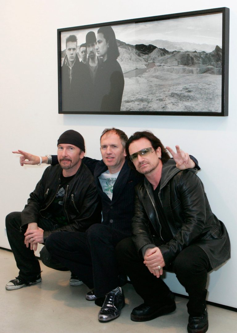FILE - This Oct. 9, 2005 file photo shows U2's Bono, right, and guitarist The Edge, left, posing with photographer Anton Corbijn in New York, under a portrait of the band from the Joshua Tree album cover. The Library of Congress announces the sound recordings it has selected for long-term preservation in the National Recording Registry Wednesday April 2, 2014. (AP Photo/Diane Bondareff, File)