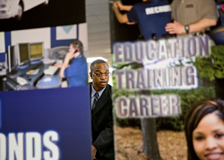 FILE - In this Thursday, Nov. 14, 2013, file photo, employment opportunity banners stand in the foreground as retired U.S. Navy Chief Jerome Porter, of Atlanta, talks with a recruiter during a job fair for veterans at the VFW Post 2681, in Marietta, Ga.  The government reports on job openings and labor turnover for October, on Tuesday, Dec. 10, 2013. (AP Photo/David Goldman, File)