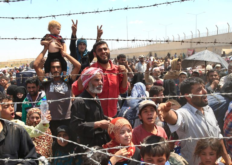 Syrian refugees gather at the Turkish border as they flee intense fighting in northern Syria between Kurdish fighters and Islamic State militants in Akcakale, southeastern Turkey. (AP Photo/Lefteris Pitarakis, File)