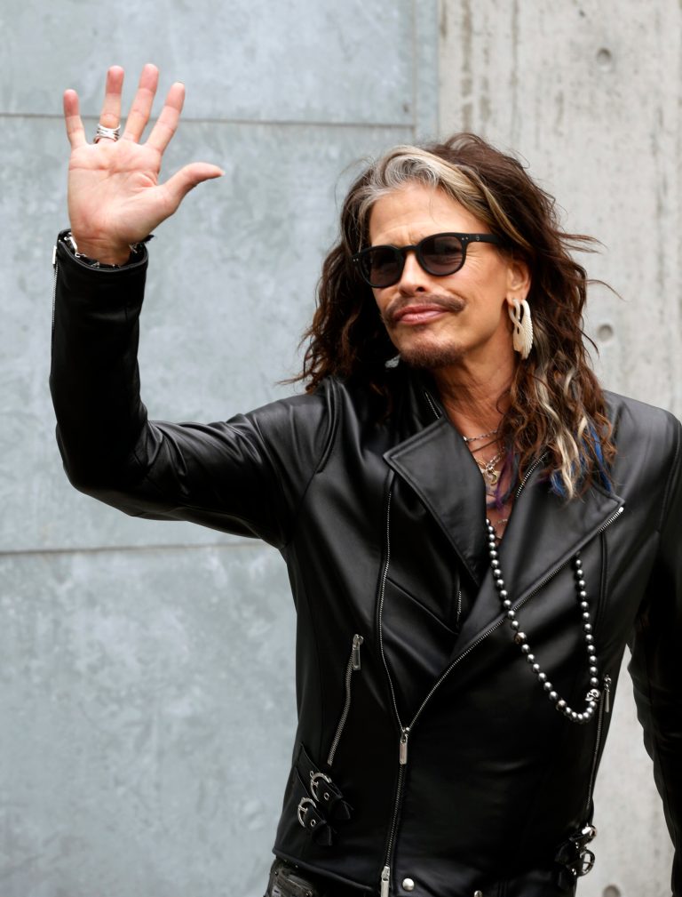 US rockstar Steven Tyler, singer of the Aerosmith group, waves at his arrival in the backstage of Emporio Armani men's Spring-Summer 2015 show, part of the Milan Fashion Week, unveiled in Milan, Italy, Monday, June 23, 2014. (AP Photo/Luca Bruno)