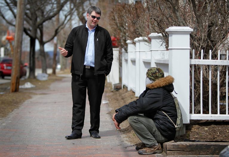 In this March 24, 2013 photo, former Marine Corps Cpl. Marshall Archer, left, a veterans' liaison for the city of Portland, Maine, speaks to a man on a street in Portland. Veterans groups are rallying to fight any proposal to change disability payments as the federal government attempts to address its long-term debt problem. They say they've sacrificed already. (AP Photo/Robert F. Bukaty)