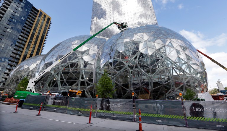 In this April 27, 2017 file photo, construction continues on three large, glass-covered domes as part of an expansion of the Amazon.com campus in downtown Seattle. Amazon said Thursday, Sept. 7, that it will spend more than $5 billion to build another headquarters in North America to house as many as 50,000 employees. It plans to stay in its sprawling Seattle headquarters and the new space will be 