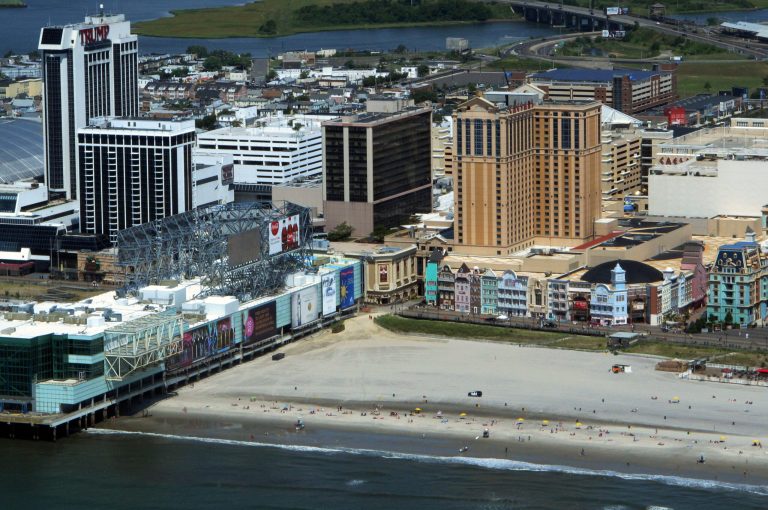 This July 11, 2014 aerial photo shows Trump Plaza, left, and Caesars Atlantic City, right, on the Atantic City N.J. Boardwalk. A report issued Aug. 29, 2014 by Wall Street firm Fitch Ratings predicts much of the gambling revenue from Trump Plaza and two other casinos closing down soon, Revel and the Showboat, will remain in Atlantic City after they are gone. (AP Photo/Wayne Parry)