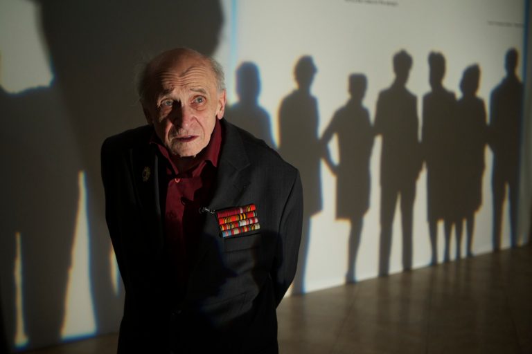   In this photo taken on Thursday, Dec. 5, 2012, artist Leonid Rabichev stands near the entrance to an exhibition at Moscow's Manezh hall on Wednesday, Russia. The 89-year-old Rabichev was one of the artists whose works were banned by Soviet leader Nikita Khruschev after an exhibition in the Manezh hall in December 1962. Fifty years later, some of the banned canvases are on display again at the same Manezh hall _ at a time when critics compare Khruschev's ban to recent charges against the Pussy Riot band and artists whose paintings have angered the Kremlin and Russiaâs dominant Orthodox Church. (AP Photo/Alexander Zemlianichenko)  