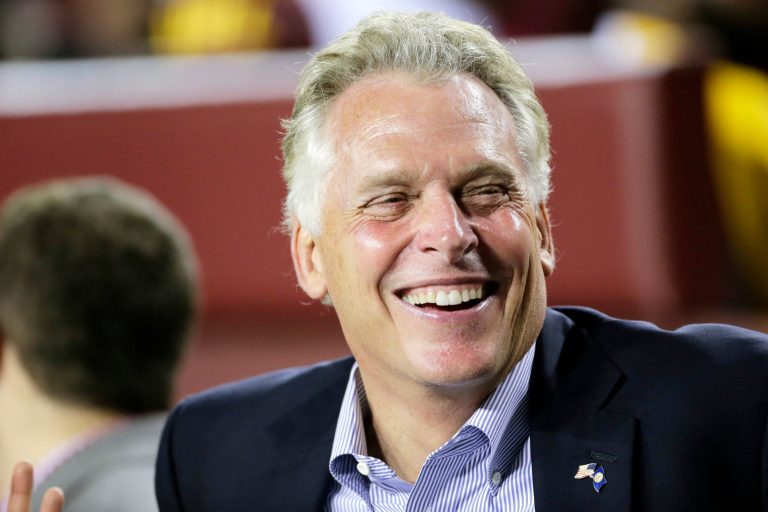 Governor of Virginia Terry McAuliffe watches from the sidelines during an NFL football game between the Oakland Raiders and Washington Redskins, Sunday, Sept. 24, 2017, in Landover, Md. (AP Photo/Mark Tenally)