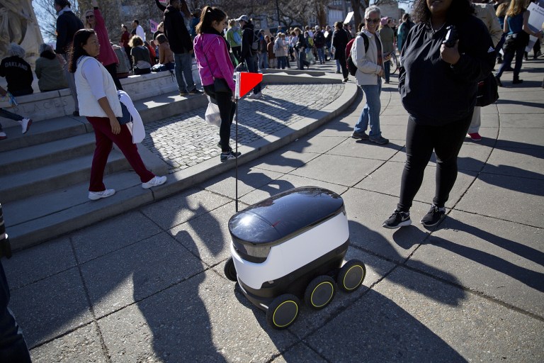 Six-wheeled ground delivery robot, from Estonia-based Starship Technologies, share the sidewalk with pedestrians at DuPont Circle, Monday, Feb. 20, 2017 in Washington. (AP Photo/Pablo Martinez Monsivais)
