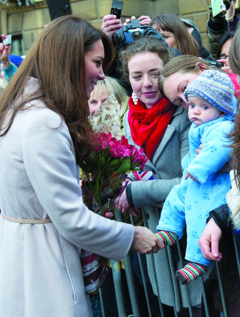 FILE - In this Wednesday Nov. 28, 2012 file photo Britain's Kate Duchess of Cambridge. left. meets with a young member of the public as she arrives at the Guildhall during a visit to Cambridge England. The Duke and Duchess of Cambridge are very pleased to announce that the Duchess of Cambridge is expecting a baby, St James's Palace officially announced Monday Dec. 3, 2012. (AP Photo/Arthur Edwards, File)