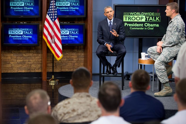 President Barack Obama, accompanied by Tech Sgt. Nathan Parry, right, speaks at a town hall with service members at Fort Meade, Md., Friday, Sept. 11, 2015, on the 14th anniversary of the 9/11 attacks. (AP Photo/Andrew Harnik)