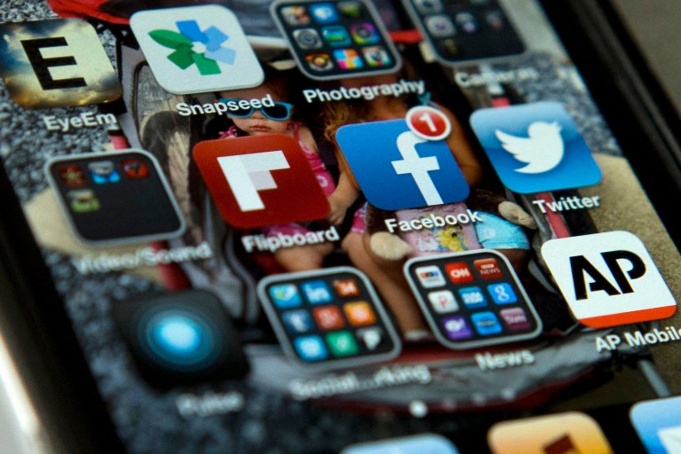 FILE - This May 21, 2013 file photo shows an iPhone in Washington with Twitter, Facebook, and other apps. Tired of that friend or relative who won't stop posting or tweeting political opinions? Online loudmouths may be annoying, but a new survey suggests they are in the minority. In a report released Tuesday, the Pew Research Center found that most people who regularly use social media sites were actually less likely to share their opinions, even offline.  (AP Photo/Evan Vucci, File)