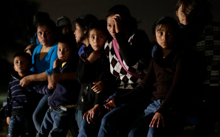 FILE - This June 25, 2014, file photo shows a group of  immigrants from Honduras and El Salvador who crossed the U.S.-Mexico border illegally are stopped in Granjeno, Texas. The influx at the border is largely families with children or by minors traveling alone. (AP Photo/Eric Gay, File)