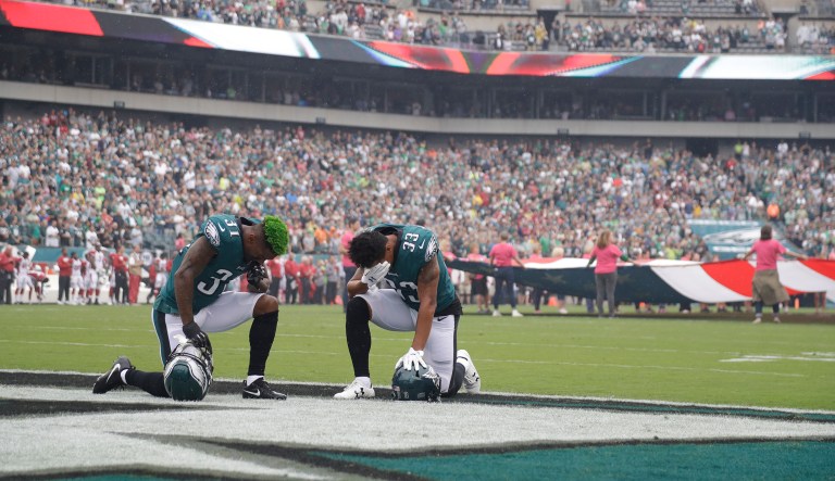 Philadelphia Eagles' players kneel before an NFL football game. (AP Photo/Michael Perez)
