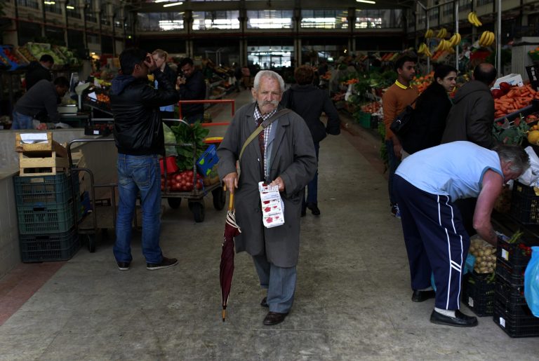 A man sells lottery tickets at Lisbon's Ribeira food market, Wednesday, April 23, 2014. Portugal's chances of ending its three-year bailout program without requiring more help have increased after interest rates fell steeply in a 10-year bond auction. The government debt agency said it raised 750 million euros ($1 billion) in Wednesday's sale at an affordable rate of 3.575 percent. That is down from 5.1 percent in February and the lowest in eight years. (AP Photo/Francisco Seco)