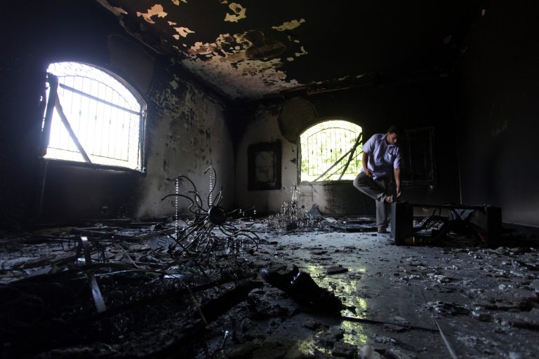 FILE - This Sept 13, 2012 file photo shows a Libyan man investigating the inside of the  U.S. Consulate in Benghazi, Libya, after an attack that killed four Americans, including Ambassador Chris Stevens. The Senate Intelligence Committee released a report on the deadly assault on the diplomatic compound in Benghazi, Libya, Wednesday, laying blame on the State Department, the late Ambassador Chris Stevens and the intelligence community for failing to communicate and heed warnings of terrorist activity in the area and protect diplomatic facilities. The highly critical report also says the U.S. military was not positioned to aid the Americans in need, though the head of Africa Command had offered military security teams that Stevens _ who was killed in the attack _ had rejected weeks before the attack. (AP Photo/Mohammad Hannon, File)
