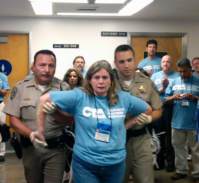An unidentified teacher is arrested, Thursday, May 12, 2011 at the state Capitol in Sacramento, Calif. More than two dozen California teachers, including the president of the state's largest teachers union, have been arrested at the state Capitol as part of a protest over education funding in the state budget. (AP Photo/Juliet Williams)