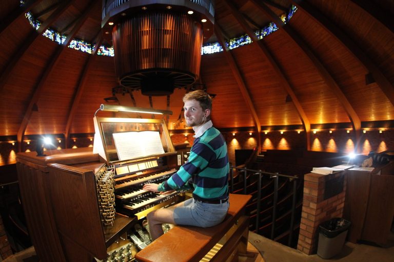  Organist Christopher Keady sits at the circular pipe organ at the Agnes Flanagan Chapel Tuesday, June 12, 2012, on the campus of Lewis & Clark College, in Portland, Ore. The Agnes Flanagan Chapel is a 16-sided architectural marvel that seats 650 under stained glass windows depicting the book of Genesis. In the early 1970s, it was also a big, conical quandary. Chapels arenât really chapels unless they have an organ, and the newly-minted structure at Portlandâs Lewis & Clark College was in need. (AP Photo/Rick Bowmer)  