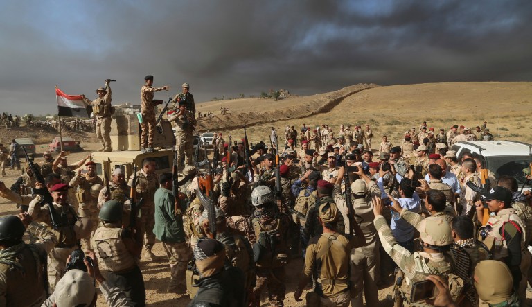 Iraqi army soldiers raise their weapons in celebration on the outskirts of Mosul, Iraq. Iraq's prime minister declared victory over the Islamic State group in Mosul after more than eight months of some of the toughest fighting Iraqi forces have faced in the more than 3-year-old war against the extremists. (AP Photo, File)