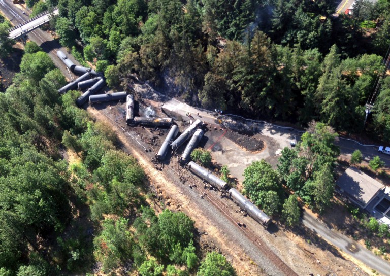This June 4, 2016, photo, provided by the Washington State Department of Ecology, shows scattered and burned oil tank cars after a train derailed and burned near Mosier, Ore. (Washington Department of Ecology via AP)