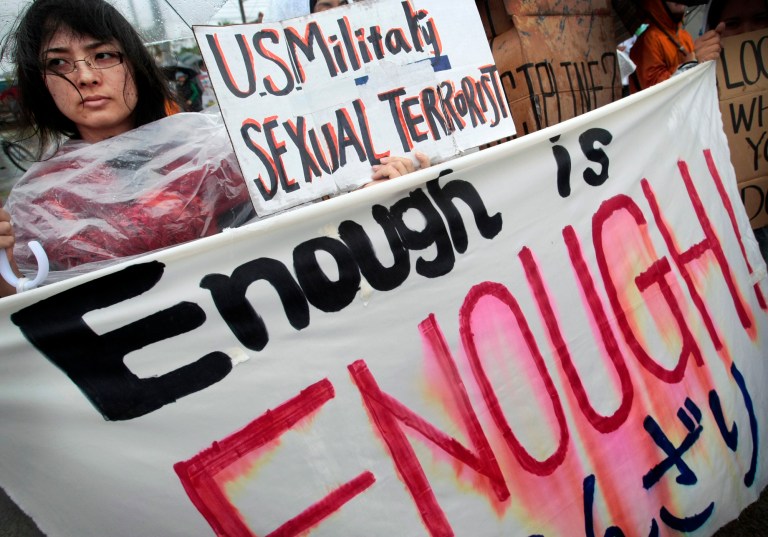 In this March 23, 2008 file photo, a protester holds a placard during a rally against an alleged rape in February of a 14-year-old girl by an American serviceman in Okinawa islands, southwestern Japan. An Associated Press investigation into the militaryâs handling of sexual assaults in Japan has found a pattern of random and inconsistent judgments in which most offenders are not incarcerated. Instead, commanders have ordered ânonjudicial punishmentsâ that ranged from docked pay to a letter of reprimand. (AP Photo/Itsuo Inouye, File)
