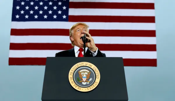 Trump sits, talks through song lowering the flag at military base amid NFL anthem controversy