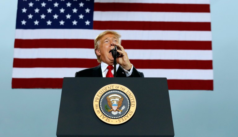 Trump not only does not stand or place his hand over his heart, but instead talks through the song and assumes it's being played to honor him or Hannity. (AP Photo/Alex Brandon)