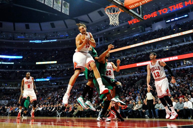   Chicago Bulls center Joakim Noah (13) rips a rebound away from Boston Celtics forward Chris Wilcox during the second quarter of an NBA basketball game, Tuesday, Dec. 18, 2012, in Chicago. (AP Photo/Brian Kersey)  