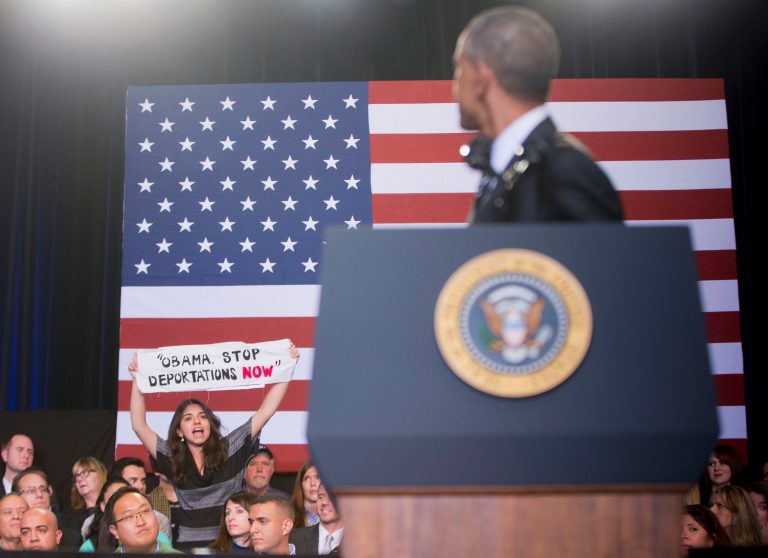 President Obama turns around as he is interrupted by a woman on stage during his remarks at the Copernicus Community Center in Chicago to discuss immigration reform, Tuesday, Nov. 25, 2014. Obama visited his hometown to promote his executive action on immigration. (AP Photo/Pablo Martinez Monsivais)