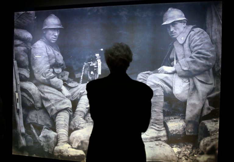 A man stands in front a WWI picture in the museum at Italy's Tomb of the Unknown Soldier in Rome, Friday, May 30, 2014. The museum will display previously unpublished World War I images and documents to commemorate the 100th anniversary of the country's involvement in the bloodshed. The exhibit, opening Saturday, contains censored images of executions and prisoners of war, as well as notifications for military tribunal death sentences that were posted on the streets of Rome. It also includes videos from the war, letters and diaries from soldiers, and recent photography that revisits the remains of trenches, shelters and villages. (AP Photo/Gregorio Borgia)