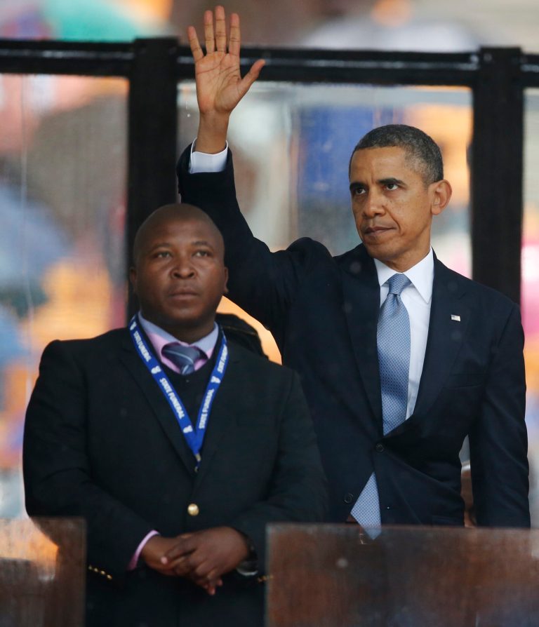President Barack Obama waves standing next to the sign language interpreter after making his speech at the memorial service for former South African president Nelson Mandela at the FNB Stadium in Soweto near Johannesburg, Tuesday, Dec. 10, 2013. South Africa's deaf federation said on Wednesday that the interpreter on stage for Mandela memorial was a 'fake', (AP Photo/Matt Dunham)