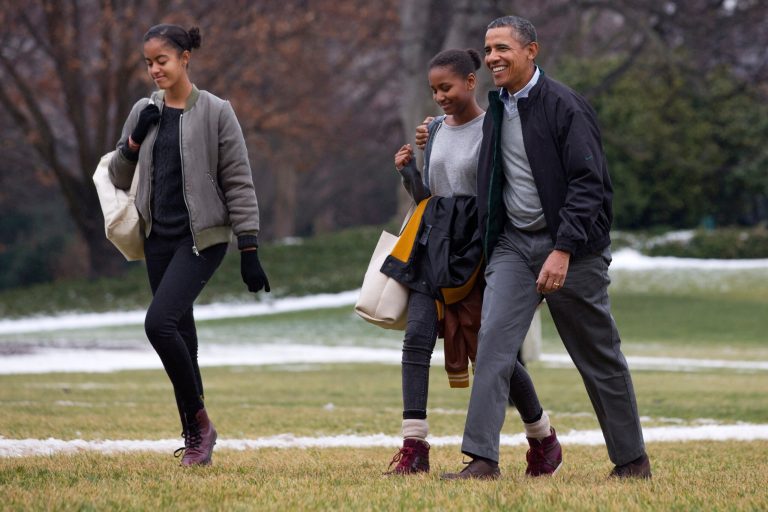 President Barack Obama, right, hugs his daughter Sasha as they and Malia, left, return to the White House from their fifteen-day family vacation in Hawaii, on the South Lawn of the White House in Washington, Sunday, Jan. 5, 2014. First lady Michelle Obama stayed behind in Hawaii as a birthday present from her husband. (AP Photo/Jacquelyn Martin)