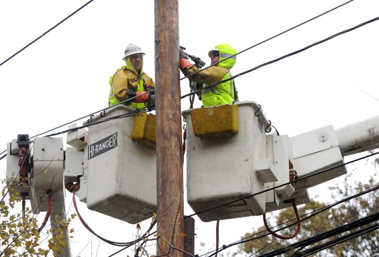   FILE- In this Nov. 7, 2012 file photo, a National Grid crew from Fredonia, N.Y. repair power lines on Port Washington Blvd. that were brought down from the effects of Superstorm Sandy, in Port Washington, N.Y. Thousands of utility workers from New York, Rhode Island and Massachusetts say many are still waiting to be fully compensated for their efforts to restore power after Superstorm Sandy. (AP Photo/Kathy Kmonicek, File)  