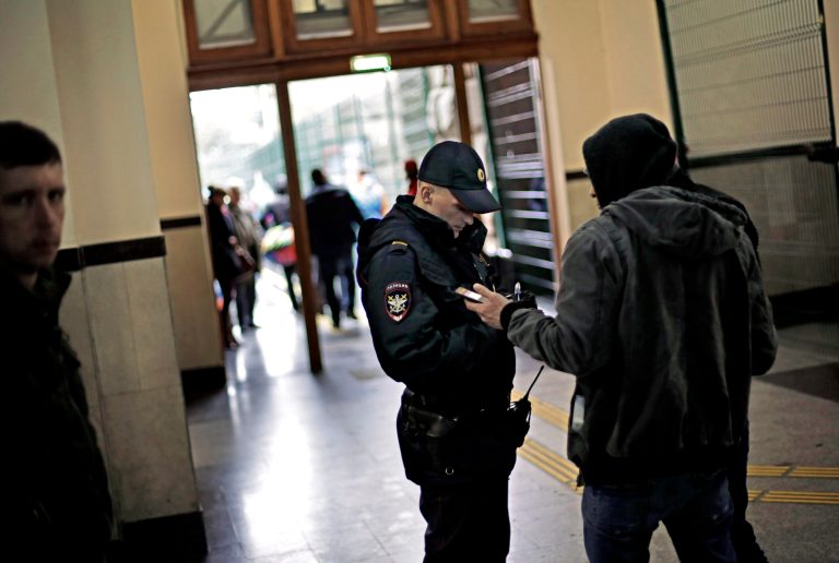 A police officer checks the identification of a passerby in the central train station, Wednesday, Jan. 29, 2014, in Sochi, Russia, home of the upcoming 2014 Winter Olympics. (AP Photo/David Goldman)