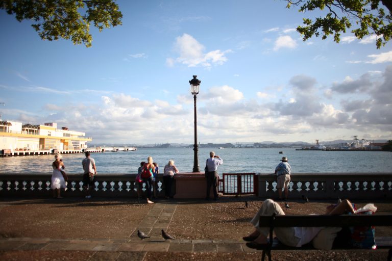 FILE - In this Nov. 23, 2011 file photo, tourists look out from the pier near the cruise ship terminal in Old San Juan, Puerto Rico. The Caribbean country is launching a two-day summit starting Thursday, April 24, 2014 to lure wealthy investors to the U.S. territory as it struggles to emerge from a nearly eight-year recession. (AP Photo/Ricardo Arduengo, File)