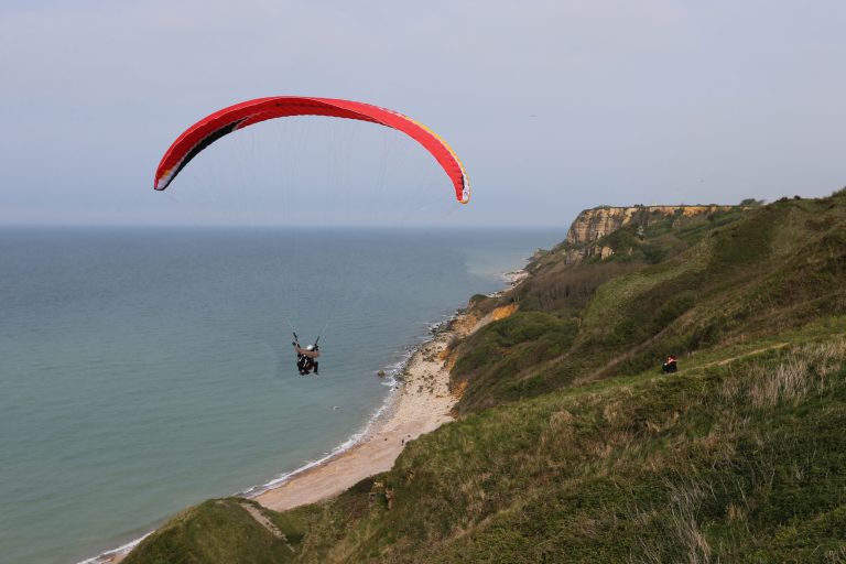 This April 24, 2014 photo shows people paragliding over the D-Day beaches, in Port en Bessin, western France. Local officials estimate that several hundred thousand tourists will flock to Normandy this summer, attracted by the 70th anniversary of D-Day. (AP Photo/David Vincent)