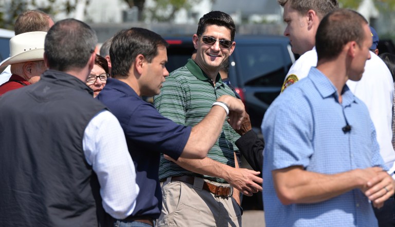 Speaker of the House Paul Ryan, center, listens as Senator Marco Rubio speaks, behind the air cargo area of Jacksonville International Airport. Ryan is in Florida touring areas effected by Hurricane Irma on Wednesday, Sept. 20, 2017. (Bruce Lipsky/The Florida Times-Union via AP)